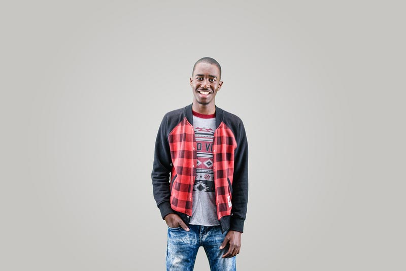 A man is happily smiling while posing on a studio background