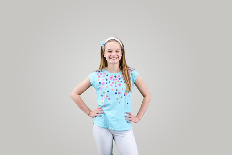 A smiling girl on a grey studio background