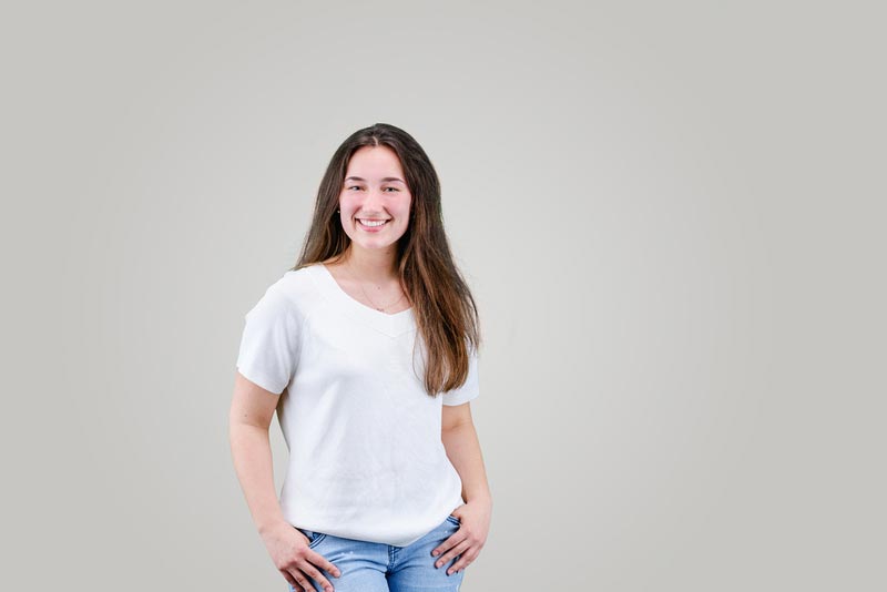 A teenage girl in a white t-short on a studio background